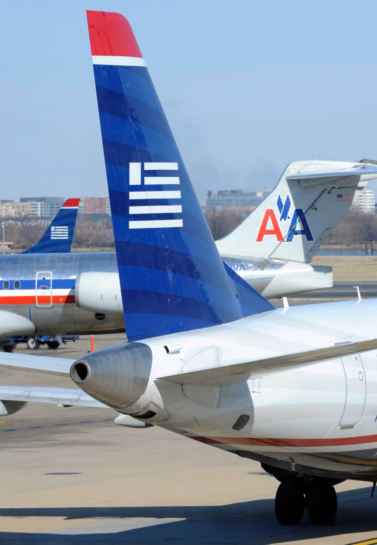 A US Airways plane (foreground) taxis past an American Airlines plane at the Ronald Reagan Washington National Airport in Arlington County, Virginia, ...