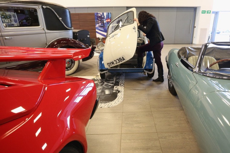 An employee of Bonhams auction house admires a 1959 BMW Isetta 300, which featured in the 'Important Motor Carts and Automobilia' auction on December ...