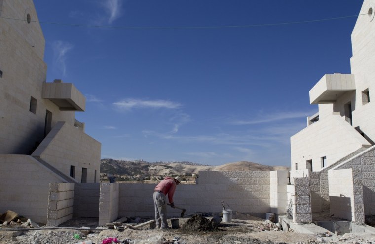 A Palestinian man works at a new housing development in the Jewish West Bank settlement of Maaleh Adumim.