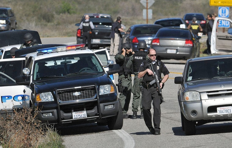 Redlands, Calif., police officers man a blockade near the entrance to the San Bernardino National Forest in Southern California on Tuesday during the manhunt for Christopher Dorner.