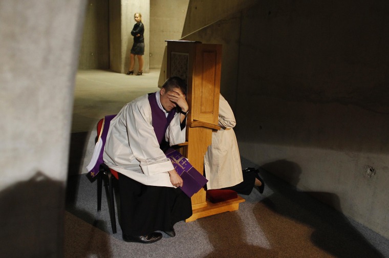 A priest listens to a confession during Mass at the Temple of Divine Providence in Warsaw, Poland, Sept. 30, 2012.