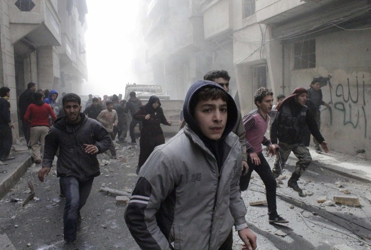 Free Syrian Army fighters and civilians react as they run after a jet missile hit the al-Myassar neighborhood of Aleppo, Syria, on Feb. 20.