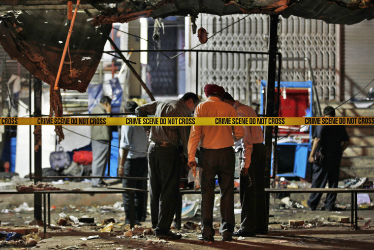 Indian officials collect evidence at one of the two bomb blast sites in Hyderabad, India, early Feb. 22, after a pair of bombs exploded the previous evening.