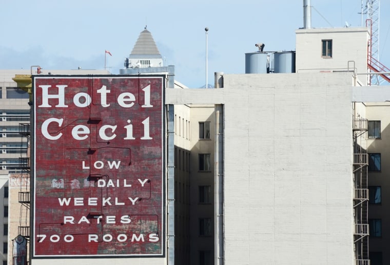A worker stands on a water tank on the roof of the Cecil Hotel in Los Angeles, where visitor Elisa Lam was found dead, adding to its grim history.
