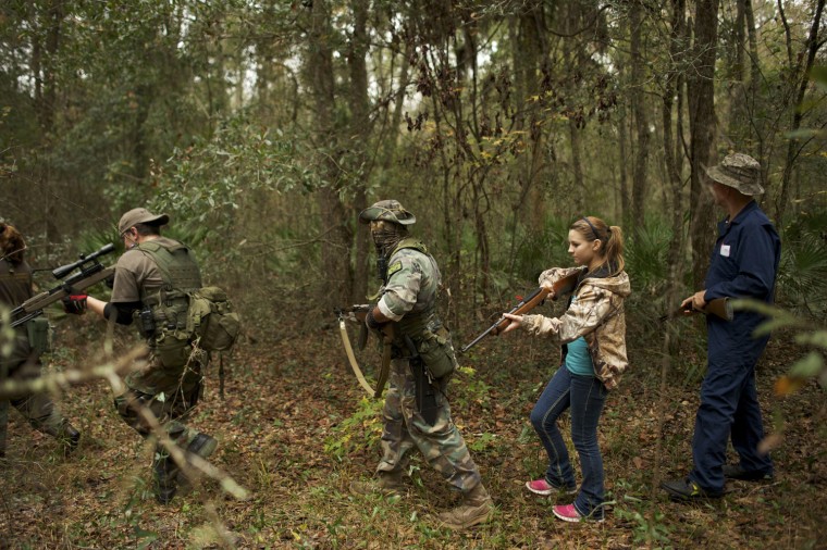 Jim Foster, leader of the North Florida Survival Group, radios group members to check their status as they perform a land navigation drill.