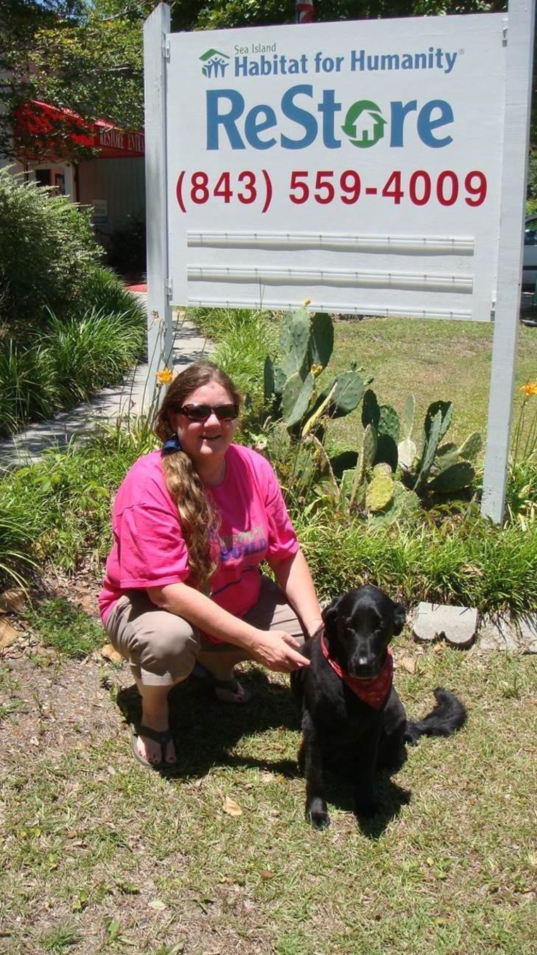 Gator and I in front of the sign at Habitat. He has been coming to work with me since he was a small puppy, when he would sleep on the front counter.