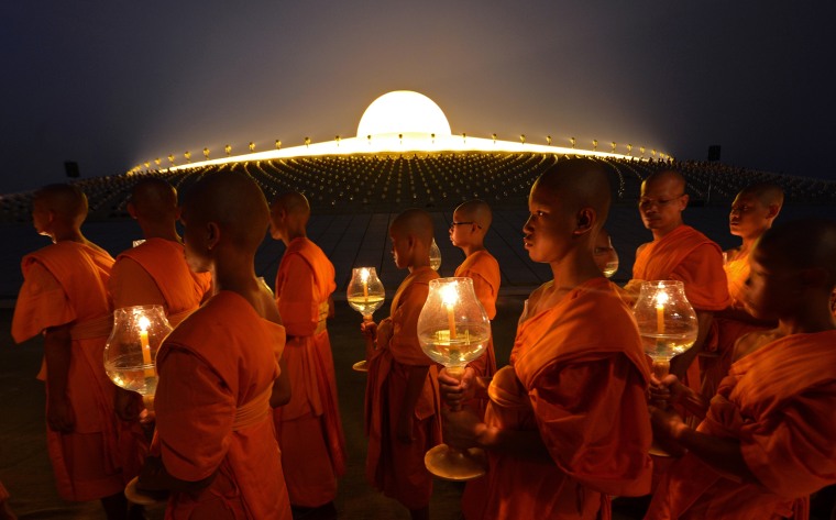 Buddhist monks hold candles as they walk around a Pagoda on Makha Bhucha Day at the Dhammakaya Temple, Feb, 25, 2013.