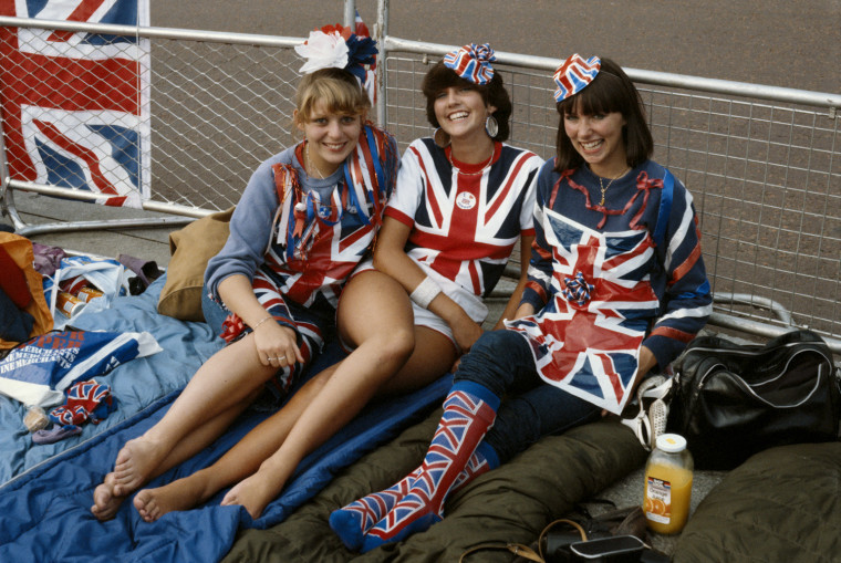 Wedding fans in their '80s finery wait to catch a glimpse of the newlyweds.