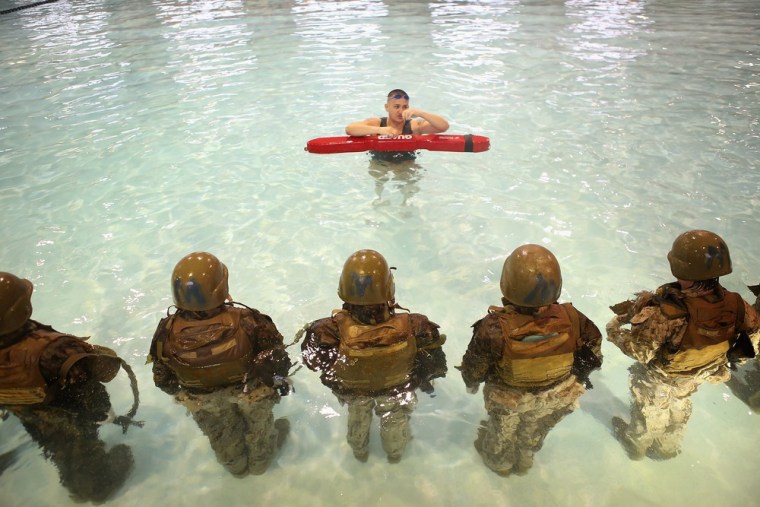 Sgt. Gustavo Ramos of Pomona, California teaches female Marine recruits to remove body armor while under water during boot camp.