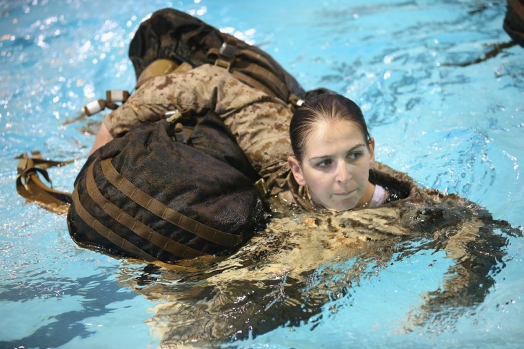 Marine recruit Chelsey Courtney of Coon Rapids, Minnesota hauls a backpack while swimming in her uniform as she is tested to determine her swimming skills during boot camp. Male and female recruits are expected to meet the same standards during their swim qualification test.