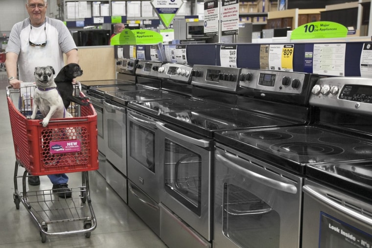 Tom Klitzke of Omaha walks his pugs Max, left, and Bear, right, past home appliances at a Lowe's store in Omaha, Neb., Friday, April 27, 2012.