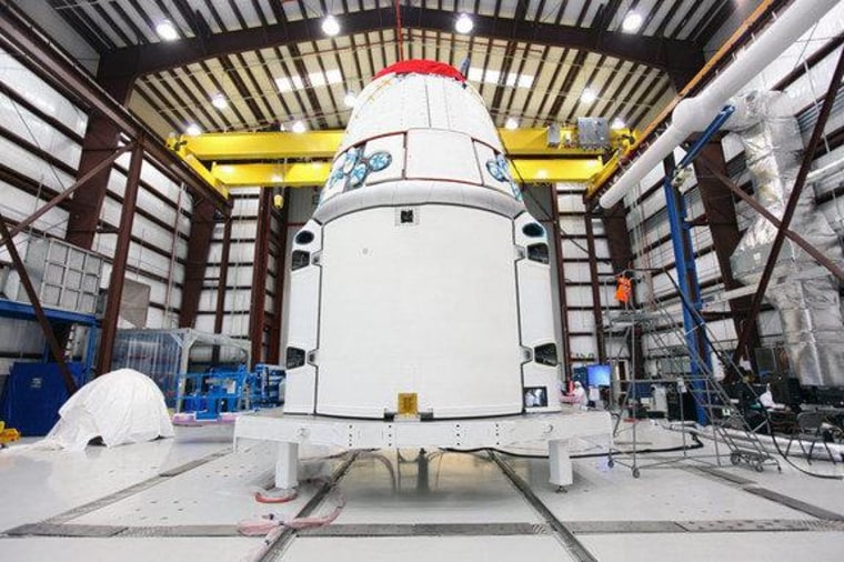 The Space Exploration Technologies, or SpaceX, Dragon spacecraft with solar array fairings attached, stands inside a processing hangar at Cape Canaveral Air Force Station, Fla. Sequestration could put SpaceX launches at risk.