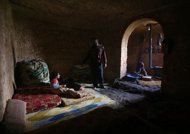 Sami speaks with his children at an underground Roman tomb which he uses with his family as shelter.