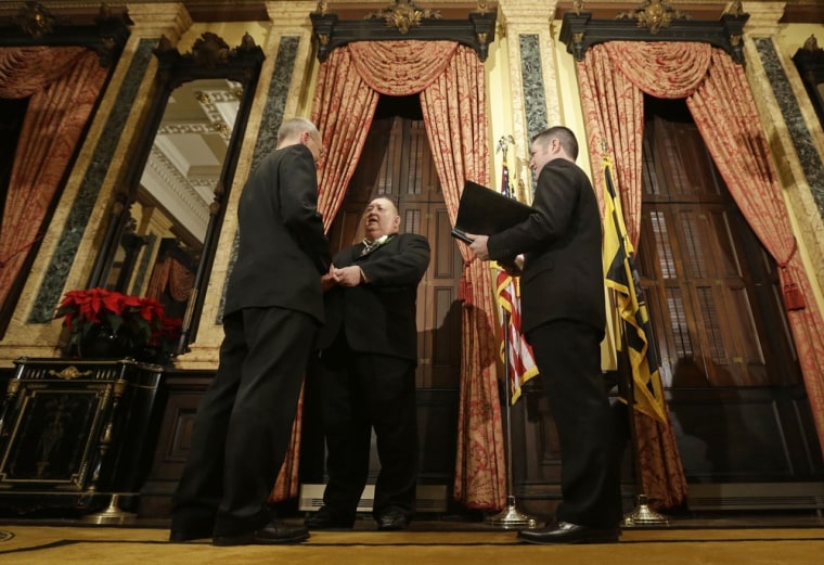 William Countryman, left, and Roy Neal exchange vows as officiant Jason Caton looks on during a marriage ceremony at City Hall in Baltimore, Tuesday, Jan. 1, 2013. Same-sex couples in Maryland are now legally permitted to marry under a new law that went into effect after midnight on Tuesday. Maryland is the first state south of the Mason-Dixon Line to approve same-sex marriage.
