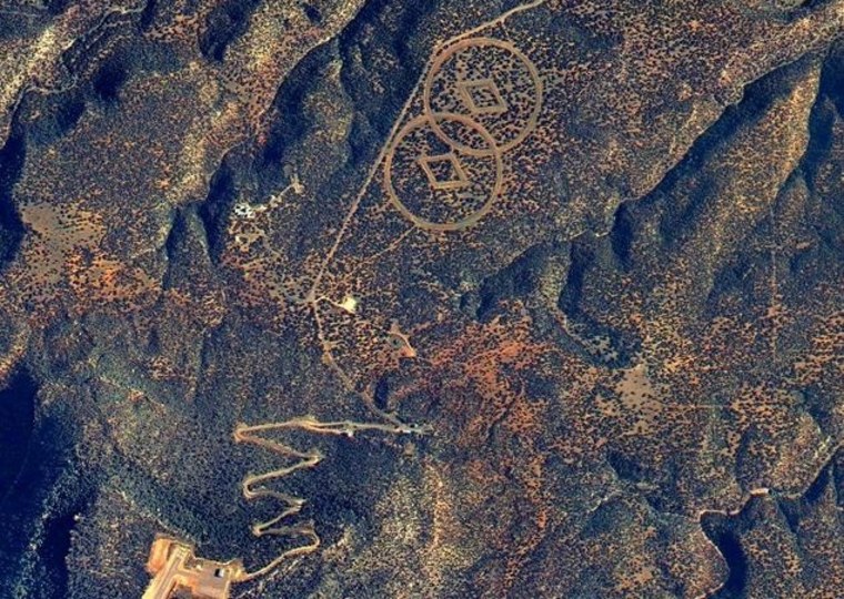 Satellite imagery shows a zigzag road leading to a pair of circle-plus-diamond symbols created in the New Mexico desert. Through the years, reports have ascribed the construction to the Church of Scientology.
