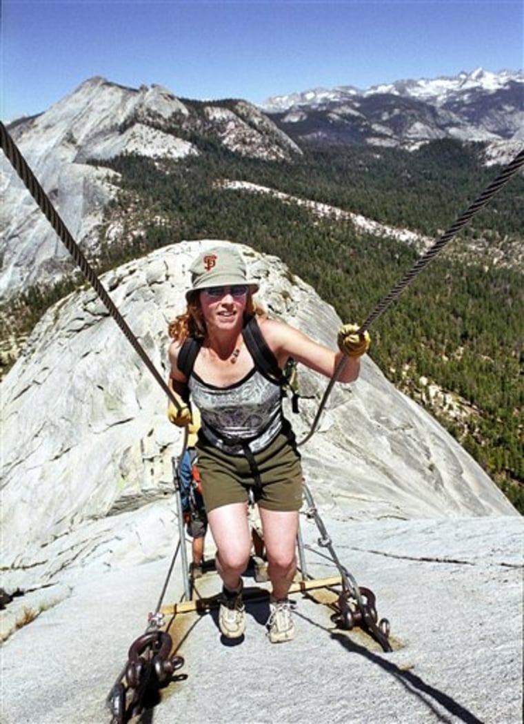 In this file photo, Thea Roberts, of Oakland, Calif., pulls herself up the cable route on the way to the summit of Half Dome.