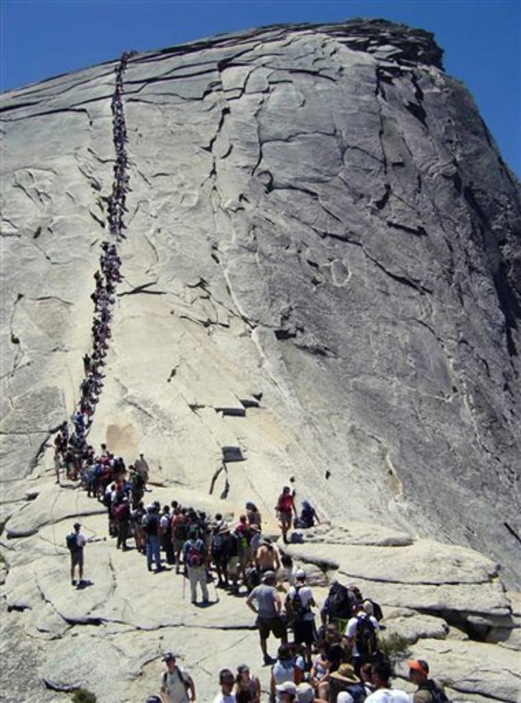 In this 2006 file photo, tourists climb Half Dome at Yosemite National Park.