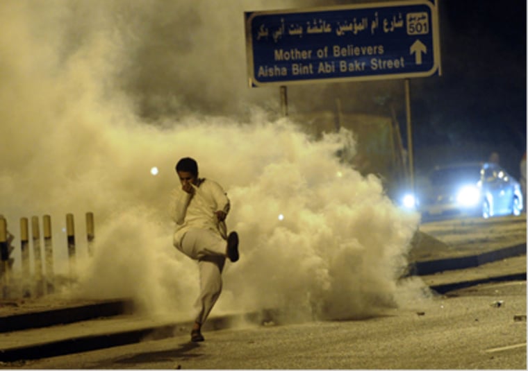 A demonstrator kicks a tear gas canister away during clashes with anti-riot police at a protest against the election results in Kuwait in this December 4, 2012 file photo.