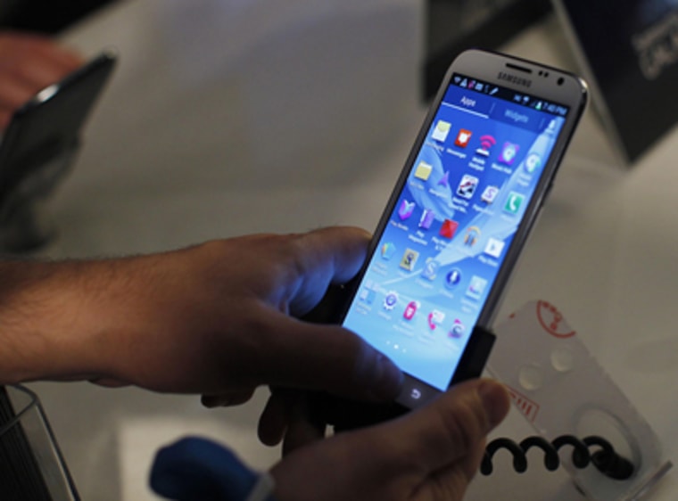 People try out the Galaxy Note II after a news conference announcing Samsung's update to its phone-tablet hybrid in New York, October 24, 2012.