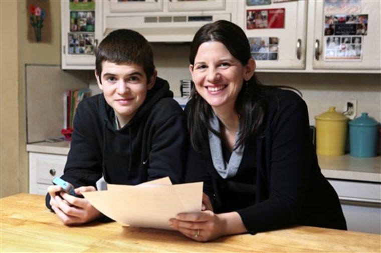 Janell Burley Hofmann, right, and her son Gregory with the contract she drafted and that Gregory signed as a condition for receiving his first Apple iPhone. (AP Photo/Michael Dwyer)
