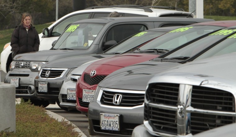 In this Jan. 11, 2011 photo, a potential car buyer looks over used cars at a dealership in Sacramento, Calif.