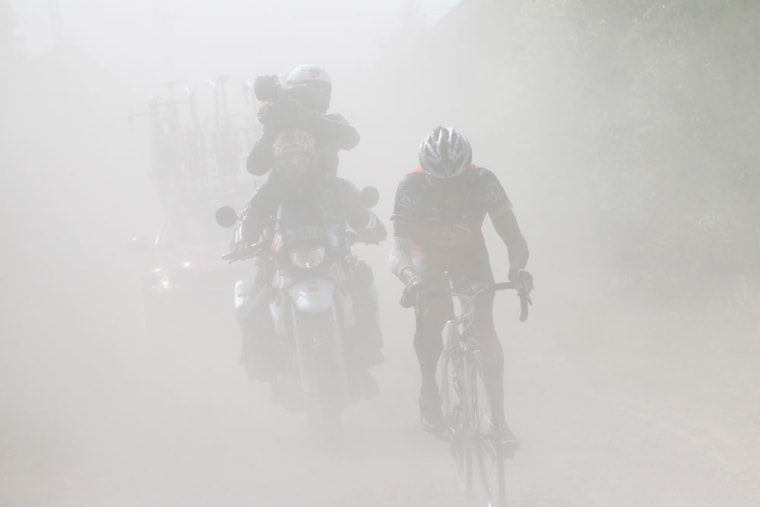 Lance Armstrong of the US rides in a cloud of dust on a cobblestone section during the third stage of the Tour de France cycling race over 213 kilometers (132.4 miles) with start in Wanze, Belgium and finish in Arenberg, France, Tuesday July 6, 2010.