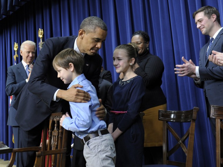 President Barack Obama, accompanied by Vice President Joe Biden, left, hugs 8-year-old letter writer Grant Fritz during a news conference on proposals to reduce gun violence, Wednesday, Jan. 16, 2013, in the South Court Auditorium at the White House in Washington. Obama and Biden were joined by law enforcement officials, lawmakers and children who wrote the president about gun violence following the shooting at an elementary school in Newtown, Conn., last month.