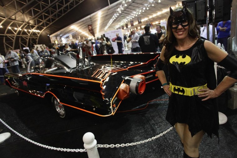 Shelli Mart poses next to the original Batmobile during the Barrett-Jackson collectors car auction in Scottsdale, Arizona, Saturday.