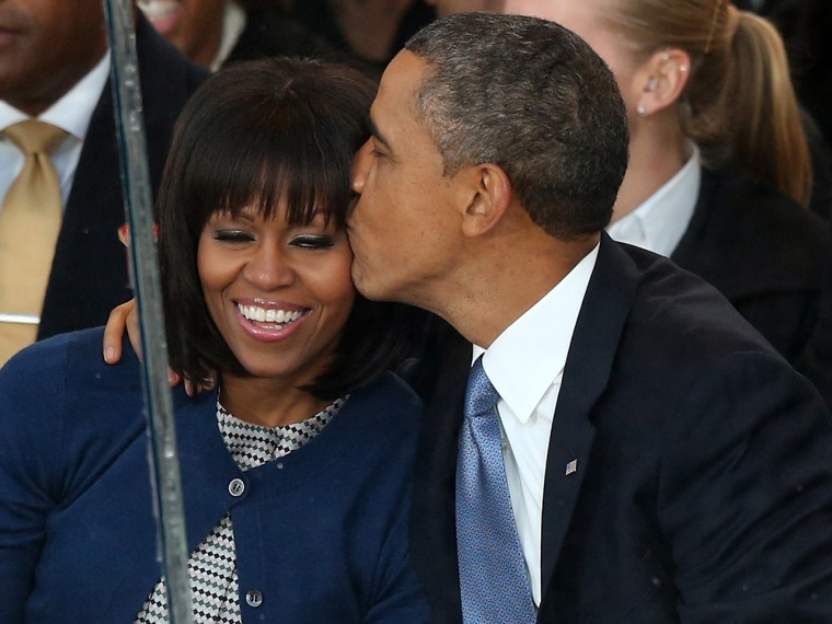 President Barack Obama kisses first lady Michelle Obama while watching the presidential inaugural parade wind through the nation's capital on Monday.