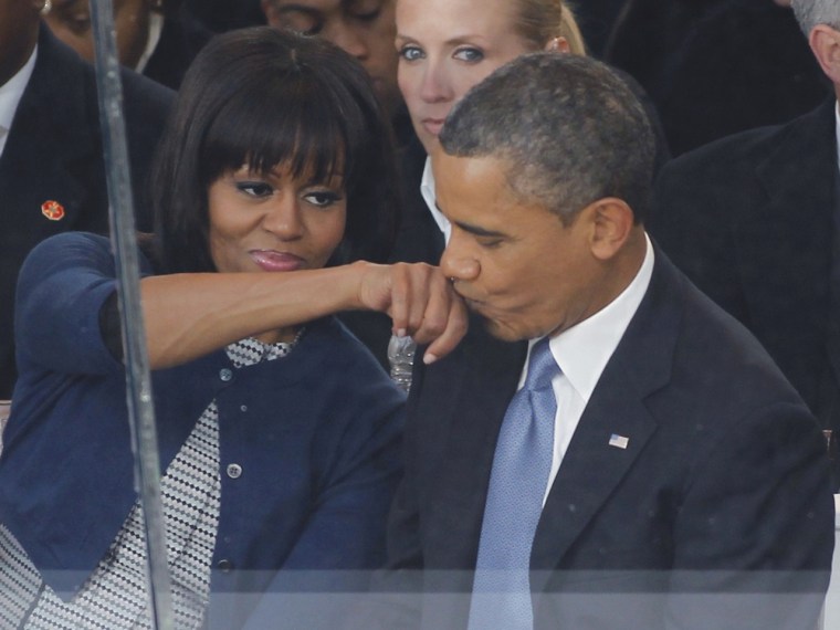 President Barack Obama kisses his wife's hand during the inaugural parade.