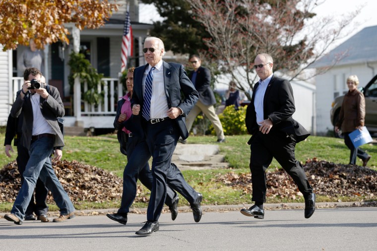 Vice President Joe Biden runs across the street from a campaign stop to meet students outside two schools on Thursday, Nov. 1, 2012, in Muscatine, Iowa.