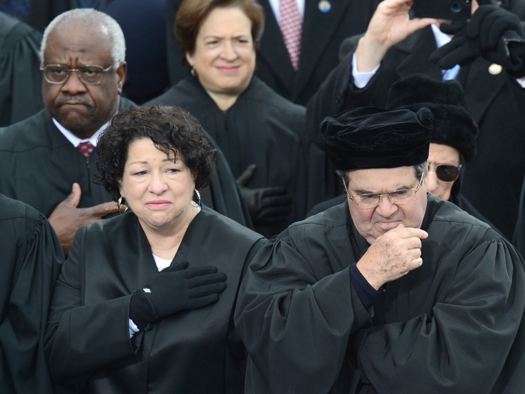 Supreme Court Justices Sonia Sotomayor and Antonin Scalia listen to the National Anthem during the 57th Presidential Inauguration ceremonial swearing-in at the US Capitol.