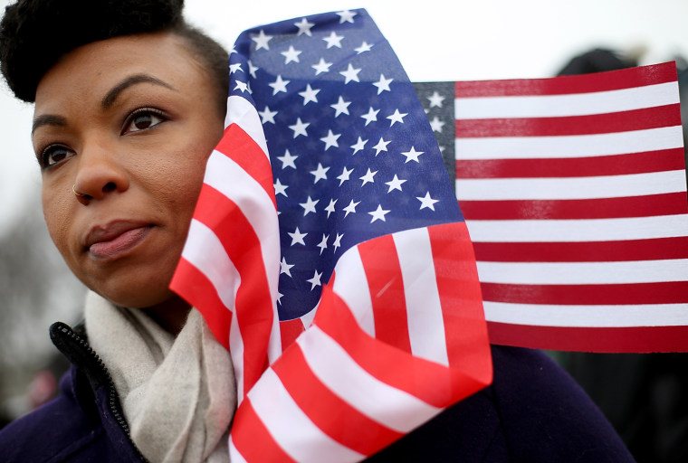 Quinnette Ellis from Tampa Bay, Fla., stands with flags near the U.S. Capitol building on the National Mall after the Inauguration ceremony on Jan. 21 in Washington, D.C.