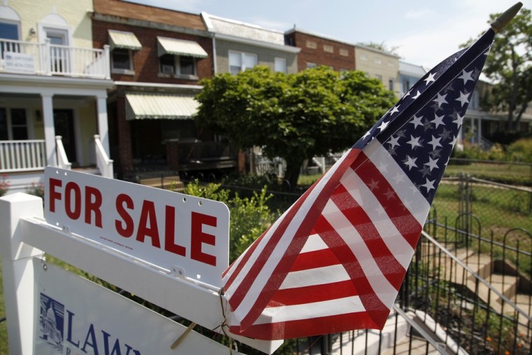 A U.S. flag decorates a for-sale sign at a home in the Capitol Hill neighborhood of Washington, DC in this August 21, 2012 file photograph.