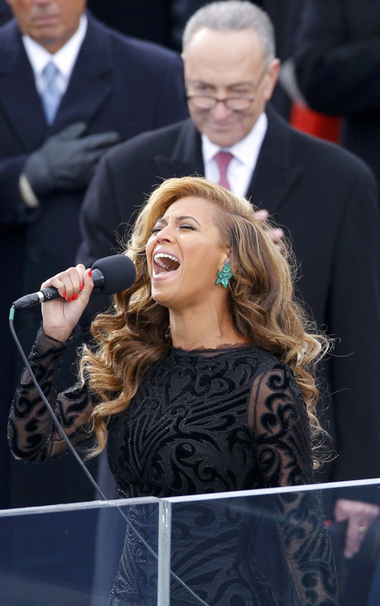 Beyonce sings the U.S. National Anthem as Senator Charles Schumer listens from behind.