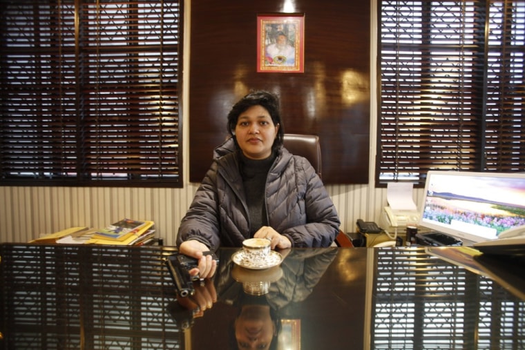 Nalini Bharatwaj, holds a gun while posing in her office in New Delhi.