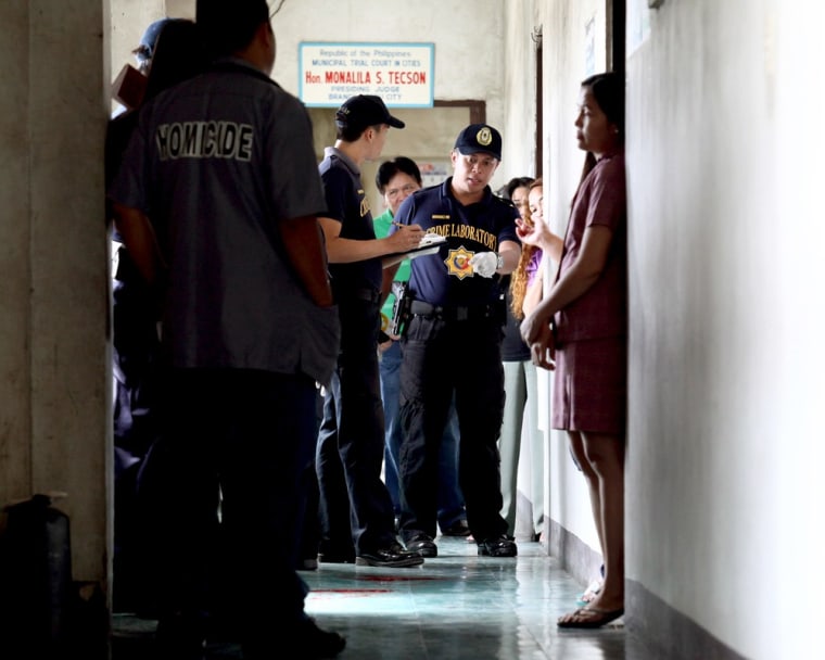 Police examine the scene where prosecutor Maria Teresa Casino was wounded at the Regional Trial Court building in Cebu city in central Philippines on Tuesday.