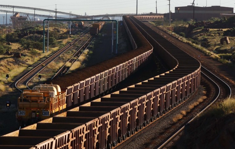 A train loaded with iron ore travels toward the Rio Tinto Parker Point iron ore facility as an empty train leaves, in Dampier in the Pilbara region of western Australia, in this file picture taken April 20, 2011.