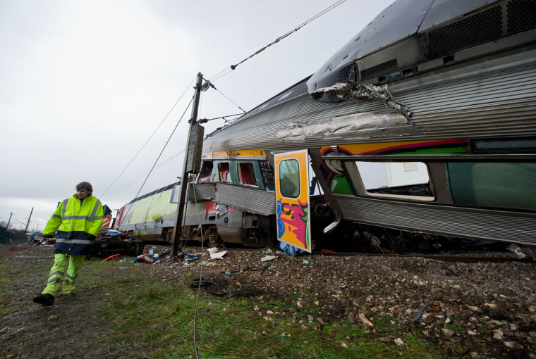 A worker walks by the wreckage at the scene of a train crash at a station in Alfarelos, Portugal, on Jan. 22.