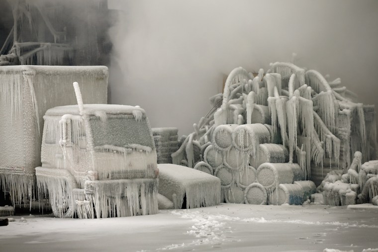A truck is covered in ice as firefighters help to extinguish a massive blaze at a vacant warehouse on Jan. 23 in Chicago, Ill.