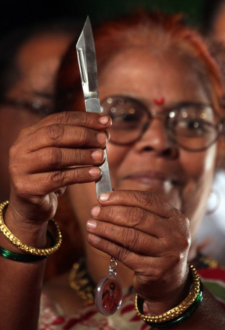 An Indian woman holds up a kinfe that was distributed by the Shiv Sena party in Mumbai, India, on Wednesday. The knives were handed out to raise awareness of the need to protect and empower the country's women, according to media reports.