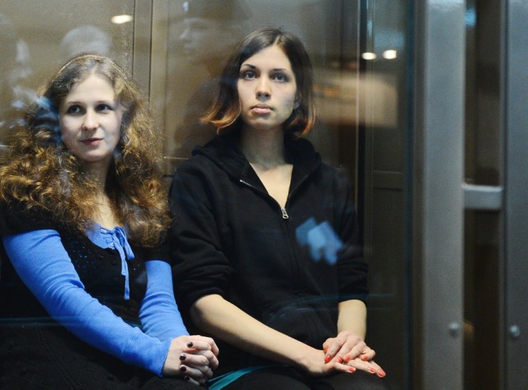 Maria Alekhina and Nadezhda Tolokonnikova sit in a glass-walled cage in a Moscow court last October.