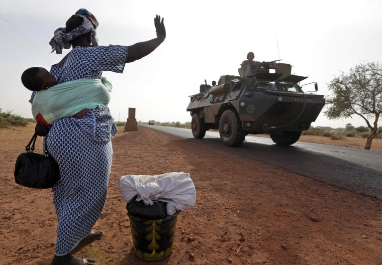 A woman waves to French soldiers Thursday as they head toward the recently liberated town of Diabaly. Some Malians are so grateful for the job the French have done routing Islamist insurgents, they say they hope the troops never leave.