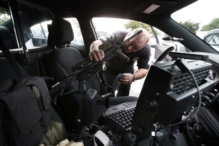 Santa Ana school police Sgt. Kevin Philips locks his rifle in a gun rack mounted in a police vehicle in Santa Ana, Calif., Jan. 24, 2013. The semiautomatic rifles look like they belong in a war zone instead of a suburban public school, but officials in this Los Angeles-area city say the high-powered weapons now in the hands of school police could prevent a massacre.