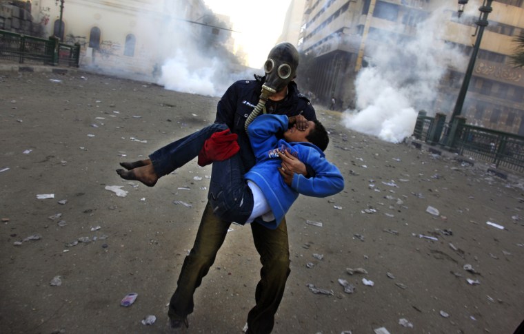 An Egyptian protester evacuates an injured boy during clashes near Tahrir Square, Cairo, Egypt, on Jan. 25. Two years after Egypt's revolution began, the country's schism was on display Friday as the mainly liberal and secular opposition held rallies saying the goals of the pro-democracy uprising have not been met and denouncing Islamist President Mohammed Morsi.