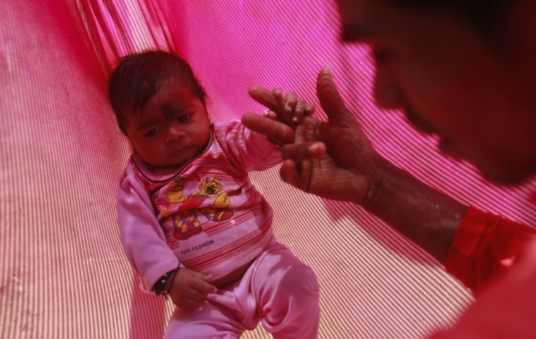 Jan. 21, 2013: Gopal Kishan plays with baby Alok.