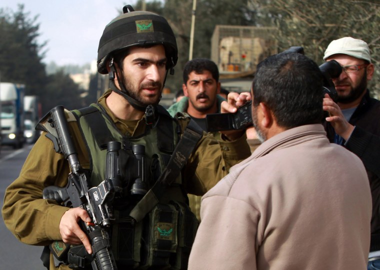 An Israeli soldier covers a small video camera that a Palestinian man was using to film a clash in El Aroub, north of Hebron, in the southern West Bank, on Wednesday. Israeli soldiers were reportedly attacked with rocks and molotov cocktails, and responded using