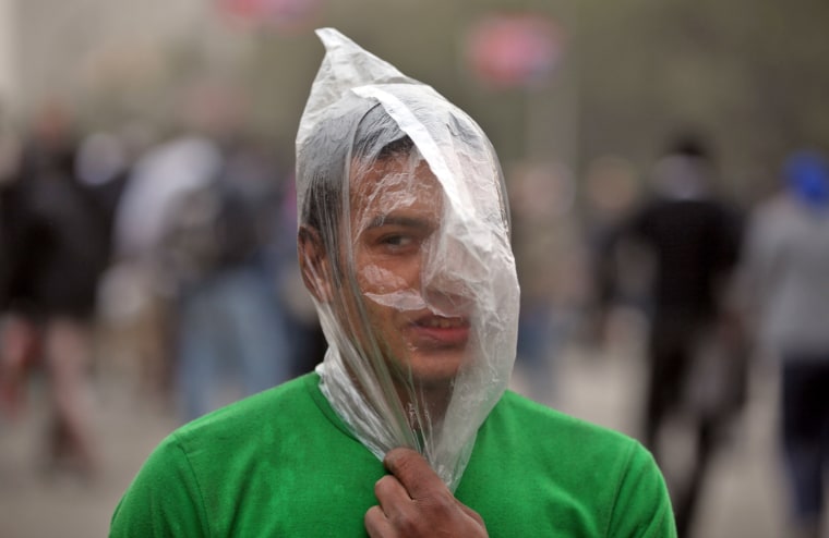 An Egyptian protester covers his face with a plastic bag to protect himslef from tear gas during clashes with riot police near Tahrir Square in Cairo on Jan. 28.
