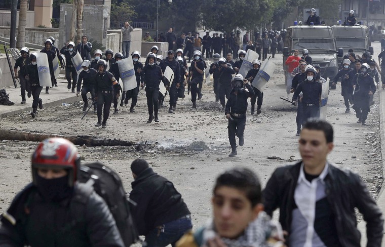 Riot police run towards anti-government protesters during clashes near Tahrir Square in Cairo on Jan. 28.