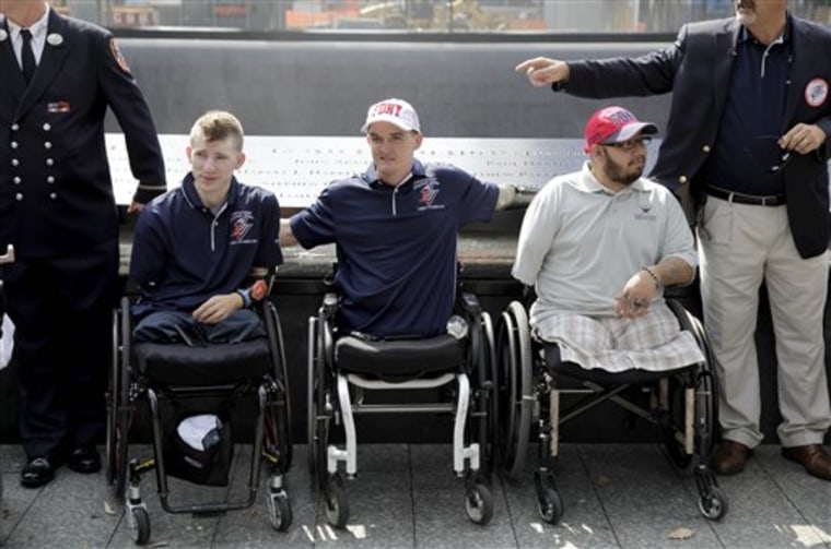 In this July 4, 2012 file photo, Army Sgt. Brendan Marrocco of Staten Island, N.Y., left, Marine Cpl. Todd Love of Atlanta, Ga., center, and Marine Cpl. Juan Dominguez of Deming, N.M., pose for a picture at the 9/11 Memorial in New York.